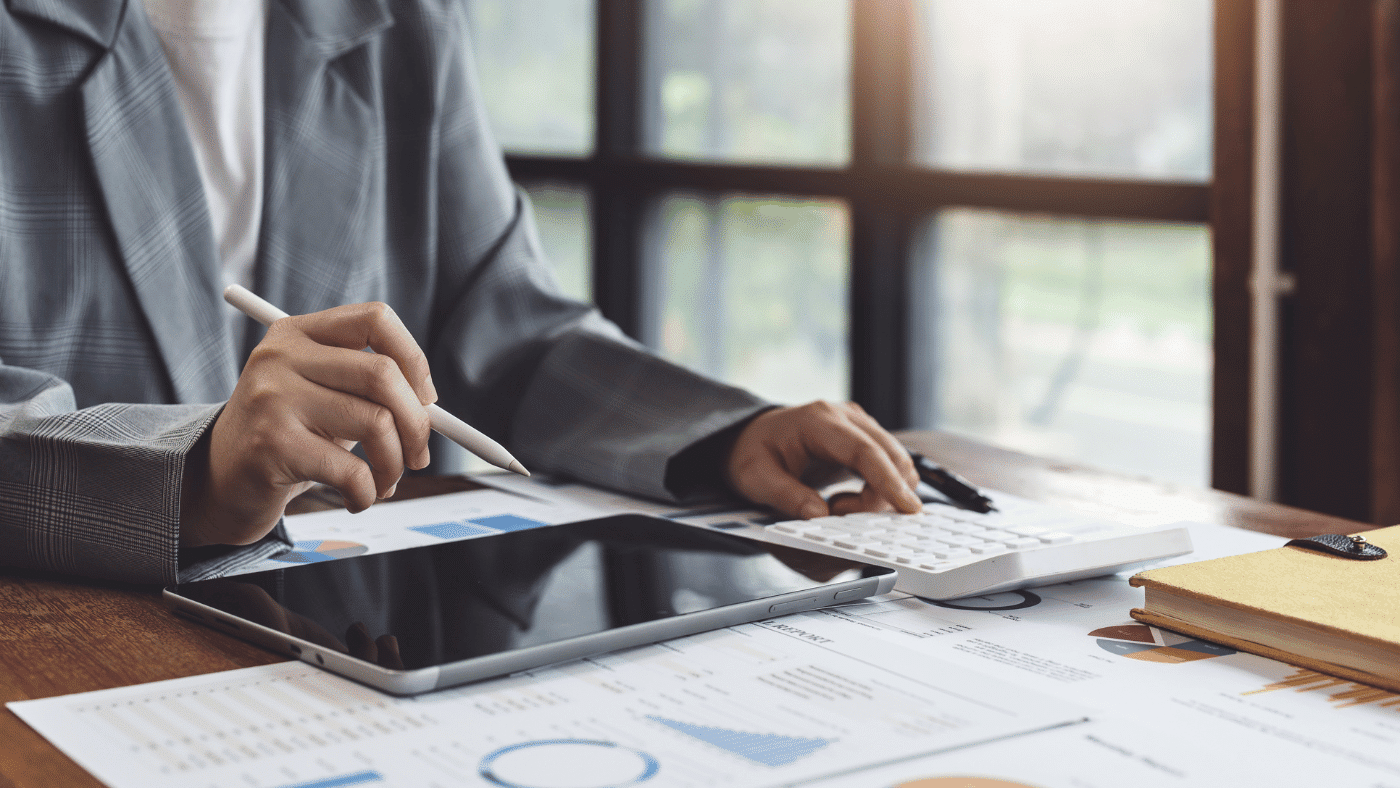 performing accounting at desk with tablet and tools