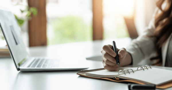 laptop on desk with notes